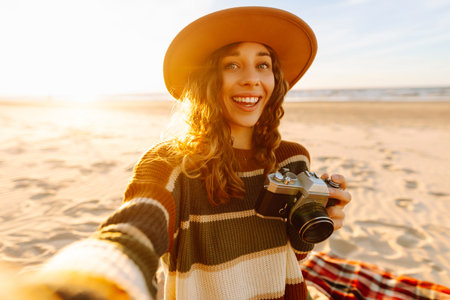 Selfie time. Young woman posing by the sea at sunset. Travel blog. Adventure, vacation concept.の写真素材