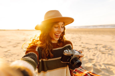 Selfie time. Young woman posing by the sea at sunset. Travel blog. Adventure, vacation concept.