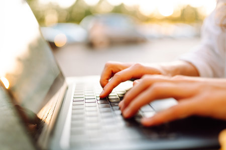 Close-up of woman hands working on laptop outdoors. Freelancing concept, business.の写真素材