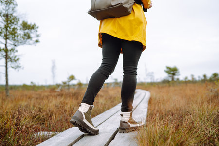 Hiking shoes of woman walking on wooden bridge. Copy Space on outdoor background. Active lifestyleの写真素材