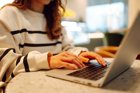 A young woman is engaged in typing on a laptop.の写真素材