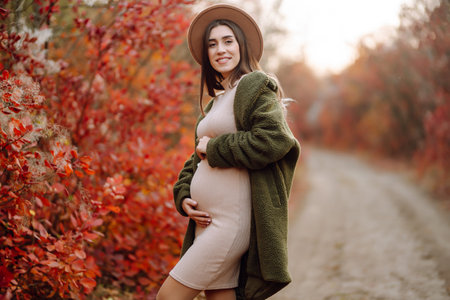 Beautiful pregnant woman feeling lovely in the park. Motherhood. Maternity. Lifestyle concept.の写真素材