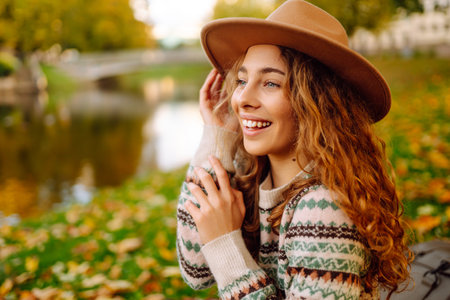 Portrait of a stylish smiling woman walking in park. street style in hat. Concept of nature, relax.の写真素材