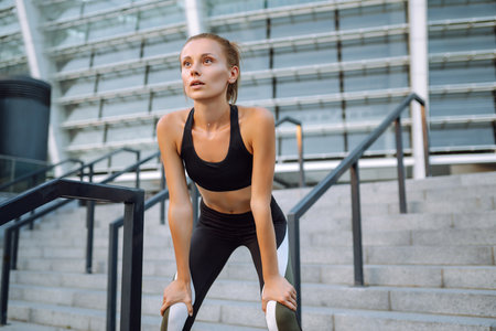Young woman in sports outfit doing exercises outdoors in the morning. Sports training, healthy...