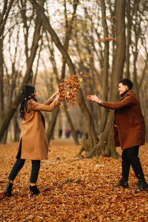 Young couple in love walking in the park on an autumn day. Enjoying time together.の写真素材