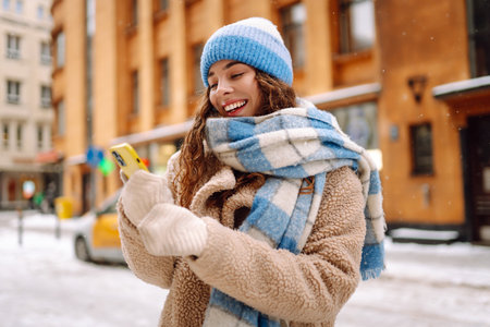 Woman is walking in city, viewing social networks in smartphone. Lifestyle, travel, tourism, technologyの写真素材