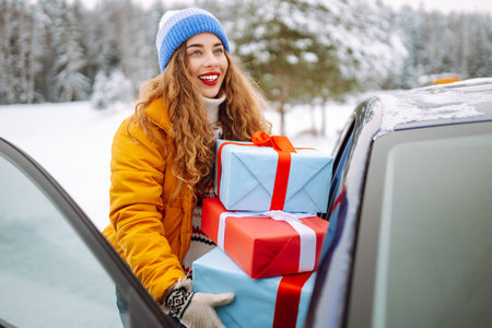 Happy young woman putting New Year's gifts into a car. The eve of the winter holidays, preparation.