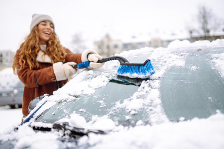 Cleaning snow from a car. Transport concept, seasonality Winter glass cleaning.