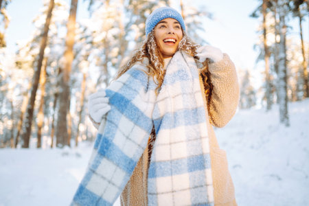 Young woman enjoys a beautiful winter day in the forest. Winter time. Cold weather.の写真素材
