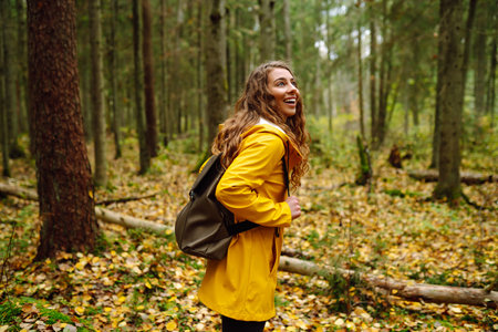 Female tourist with backpack in forest walks, enjoys nature of forest. Concept of nature, relaxationの写真素材