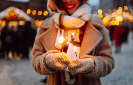 Burning sparklers in woman's hands. Winter holidays. Young smiling woman holding burning sparklerの写真素材