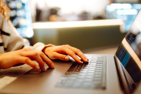 A young woman is engaged in typing on a laptop.