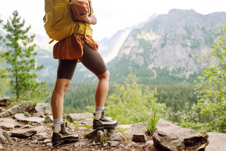 Close-up of female legs in hiking boots on a hiking trail. Travel, vacation. The concept of nature.