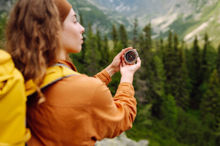 Wanderlust concept. Stylish woman holding a compass in her hand while traveling in the mountains.の写真素材
