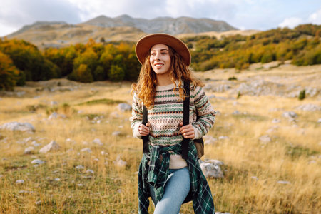 Young woman enjoys sunny afternoon in mountains. Tourism. Active lifestyle.の写真素材