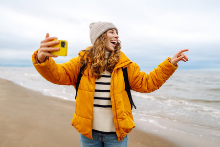 Portrait of a happy woman with a phone on the seashore. Adventure concept, vacation.