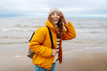 Attractive woman on a windy cold beach. Travel, nature concept.