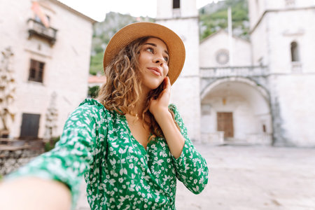 Beautiful woman walks the streets and takes selfie using smartphone camera. Blogging, lifestyle