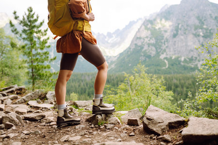 Close-up of female legs in hiking boots on a hiking trail. Travel, vacation. The concept of nature.の写真素材