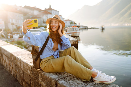 Young woman walks the streets and takes selfie using smartphone camera. Tourism and technology
