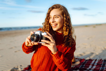 Happy woman with retro camera on the beach. Travel, weekend, relax and lifestyle concept.