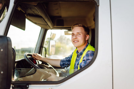Driver at the wheel of a truck at work. Driver or forwarder on truck on a transshipment point