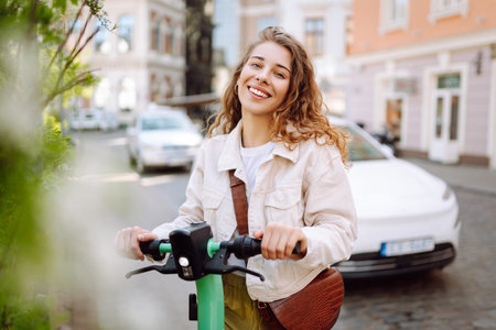 Beautiful woman riding an electric scooter. Street-style, Ecological transport. Active lifestyle.