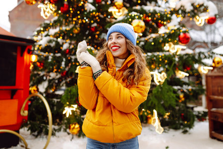 A happy woman in a bright yellow jacket and red lips walks through the Christmas market.