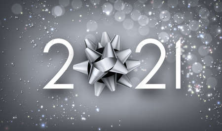 White 2021 sign on light gray background with shiny lights confetti. Silver bow instead of 0 in...