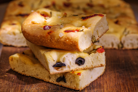 Focaccia with black olives, pepper, capers and rosemaryの写真素材