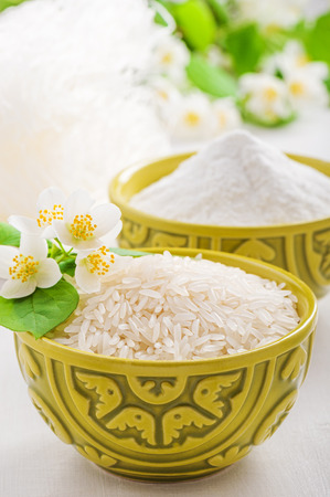 Bowls of rice and rice flour and jasmine flowerの写真素材
