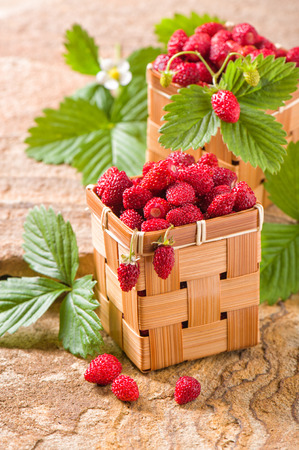 Strawberries in a basket on a stoneの写真素材