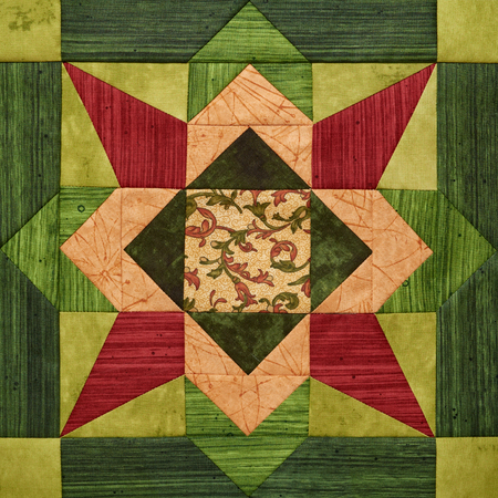 Bright orange-green geometric patchwork block from pieces of fabrics, detail of quiltの写真素材