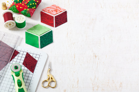 Cutting and preparing diamonds for sewing a quilt in Christmas colors, quilting accessories.