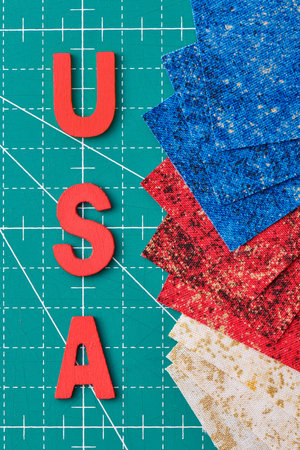 Wooden letters consisting to the abbreviation USA and square pieces of fabric in the US flag colors...