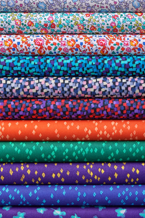 Stack of colorful cotton quilting fabrics as a background image