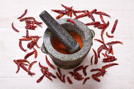 Pestle with mortar, surrounded by dried chili peppers. Cooking spicesの写真素材