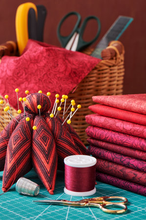 Set of red fabric and sewing tools on craft mat, close-up view