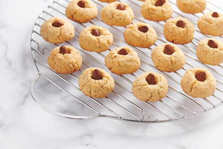 Fresh baked almond cookies on stainless steel grille, marble backgroundの写真素材