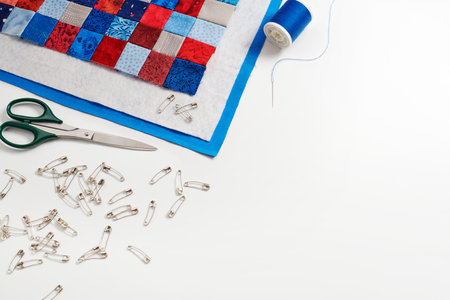 Assembling of a quilt sandwich, curved basting pins and sewing accessories, space for text
