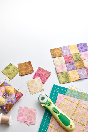 Bright square pieces of fabric, quilting tools, sewing equipment, traditional patchwork, space for...