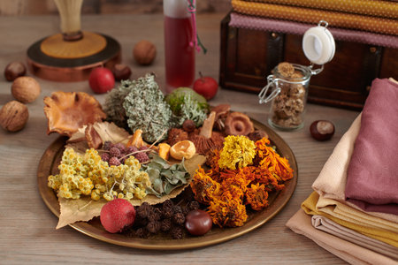 Plant material for organic dyeing of fabrics on a dish, stack of hand-dyed fabrics on the background wooden chest with fabricsの写真素材