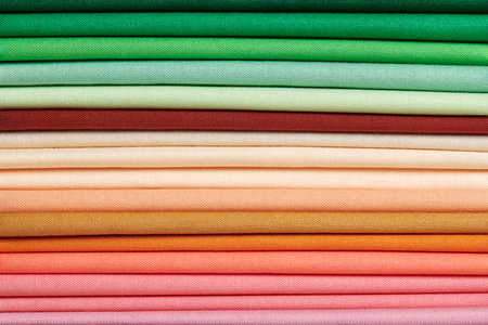 Stack of bright self-colored cotton fabrics as a background image