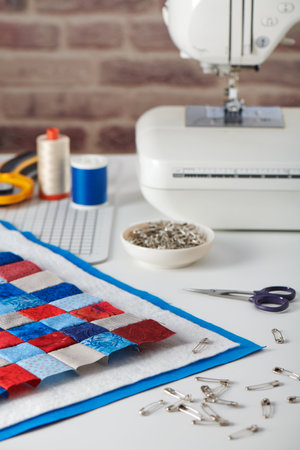 Quilt sandwich, curved basting pins, sewing machine and sewing accessoriesの写真素材