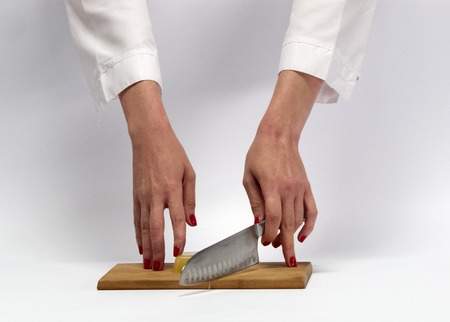 Female hands with kitchen objects on a white background.