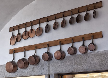 Kitchenware on wooden shelves. Group of stainless steel kitchenware.の写真素材