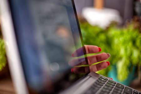 female hand holds a laptop, close up.