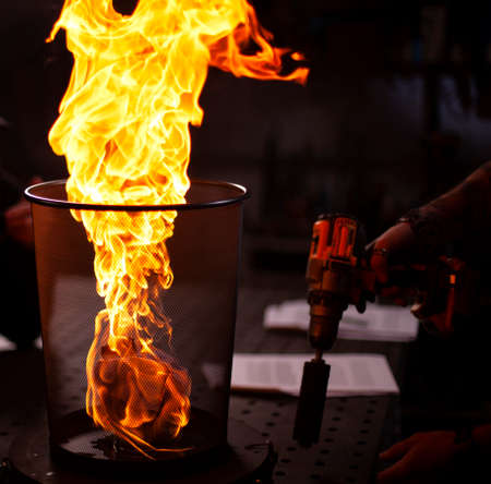 Gas burner made of brass with a flame escaping from it.