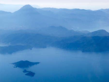 Aerial view of airplane wing and mountain peaks at European from above on airplane window.の写真素材