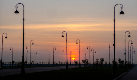 electric lamp posts against the backdrop of the setting sun.